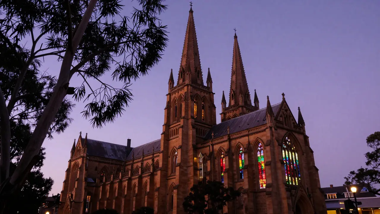 St. Mary’s Cathedral in Sydney at twilight, twin spires glowing with colored light against dusk sky.